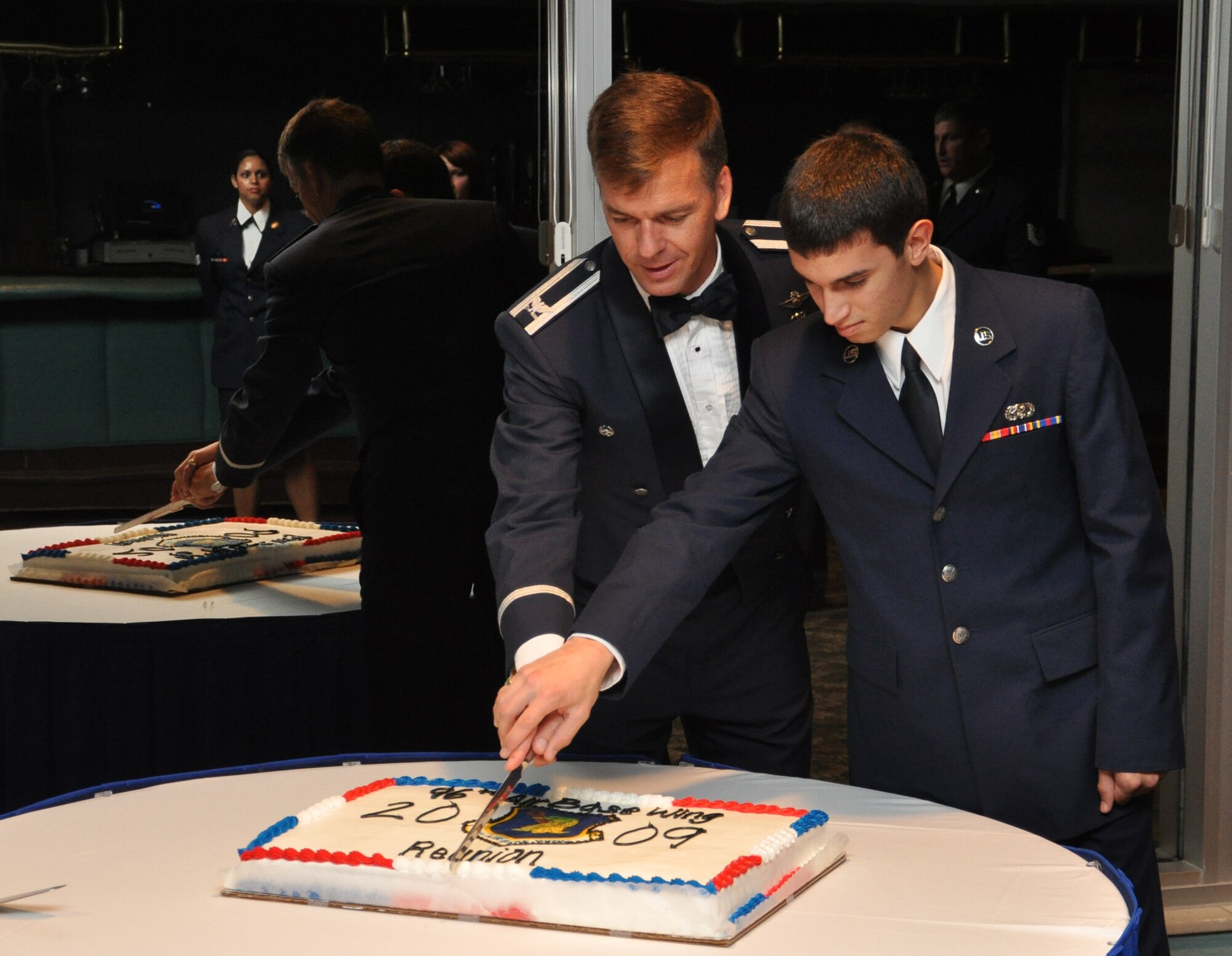 Col. Bruce McClintock, 96th Air Base Wing commander, and Airman Peter Jones, 96th Logistics Readiness Squadron, cut the cake during the Gathering of Falcons Dining Out Sept. 19 at the Eglin officers' club.  The event had three guest speakers from different eras of Eglin.  (U.S. Air Force photo/Staff Sgt. Bryan Franks.)
