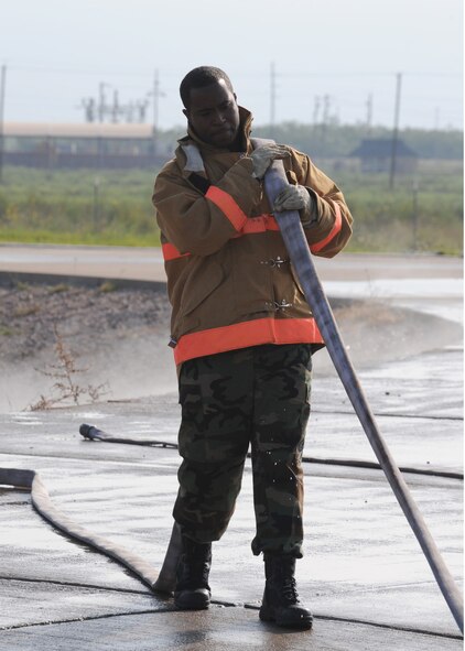 DYESS AIR FORCE BASE, Texas – Staff Sgt. Daniel Utley, 7th Civil Engineer Squadron, rolls up a hose after a controlled pit fire here Sept. 19. Firefighters perform controlled burns to keep their skills current. (U.S. Air Force photo by Senior Airman Jennifer Romig)