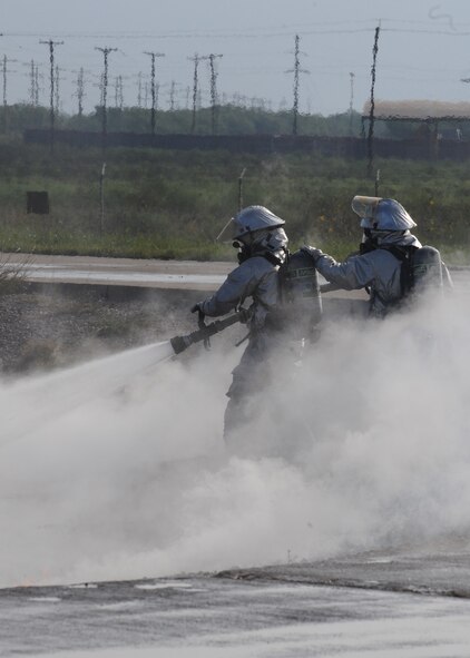 DYESS AIR FORCE BASE, Texas – Air Force National Guardsmen Tech. Sgt. Brad Harmon and Staff Sgt. Brett Burke, 140th Civil Engineer Squadron, Buckley, Colo., extinguish a controlled pit fire during a training exercise here Sept. 19. Six guardsmen from Buckley came to Dyess to perform their annual two weeks of training with Dyess firefighters, to get the latest firefighting training. (U.S. Air Force photo by Senior Airman Jennifer Romig)