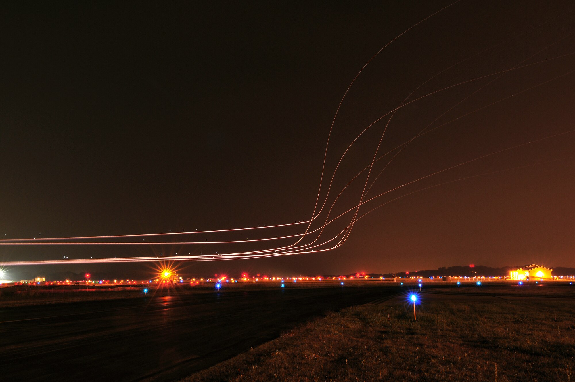 The glow from the afterburners of multiple  F-16 fighter jets adorn the night sky over Dane County Regional Airport early on the morning of September 22, 2009. The 115th Fighter Wing launched 14 F-16s early Tuesday morning as part of the wings scheduled Aerospace Expeditionary Force rotation that began last week when approximately 200 of the unit's members deployed in support of Operation Iraqi Freedom. (US Air Force photo by Master Sgt. Paul Gorman)