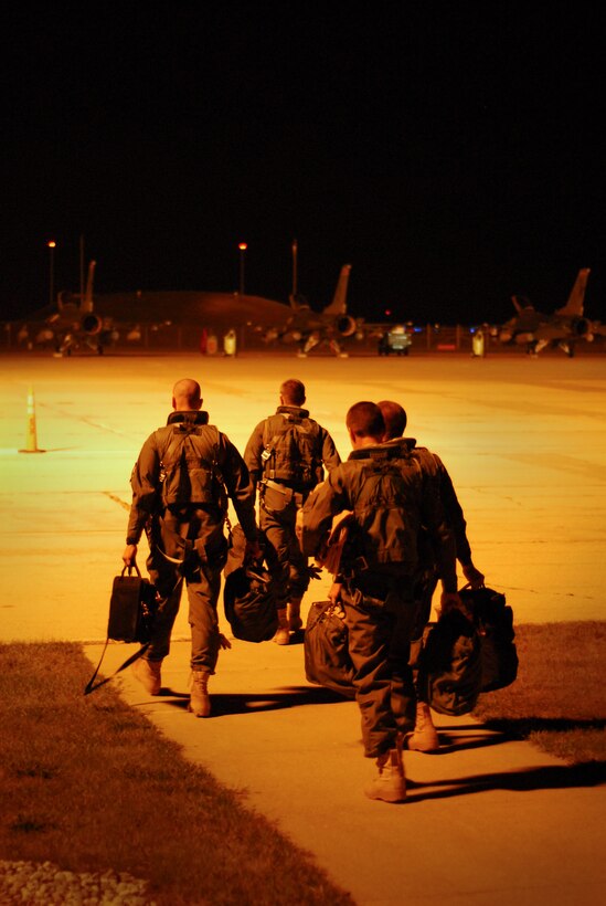 Pilots from the 115th Fighter Wing step to their F-16 Fighting Falcons after receiving a pre-departure briefling for their flight to Iraq, in support of Operation Iraqi Freedom, Sept 22.  The 115th launched 14 F-16s early Tuesday morning as a part of the Wing's scheduled Air Expeditionary Force rotation that began last week when approximately 200 Airmen deployed to theater.  (U.S. Air Force photo by Staff Sgt. Ashley Bell)