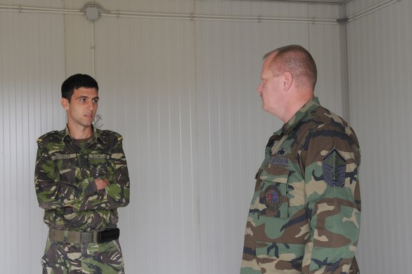 U.S. Air Force Master Sgt. Jerry McDonald, 1st Communications Maintenance Squadron special communications team member and Romanian 2nd Lt. Adrian Dio?an, engineer platoon leader, discuss what is needed for the installation of the Tactical Air Navigation System during the final site inspection, Camp Turzii, Romania, Sept. 17, 2009. The installation of the TACAN will provide better communication capabilities between the air and ground forces in the area, and it will also help strengthen the bonds between the United States and the host nation. (U.S. Air Force photo by Airman 1st Class Alexandria Mosness)