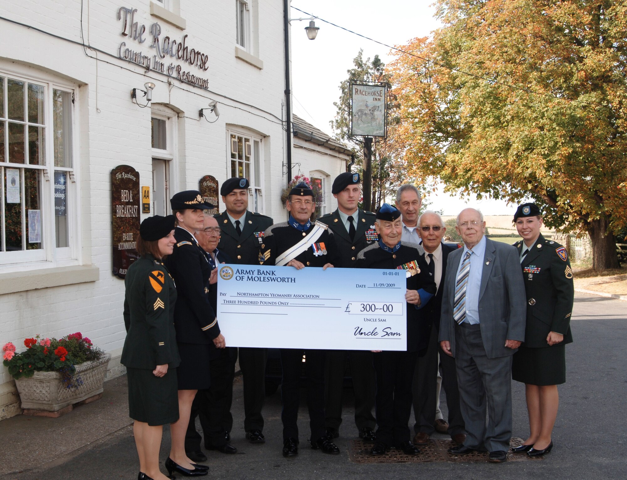 US Army Maj. Jennifer Wabals presents a check to Staff Sgt. William Hornsbey and Sgt. Tanky Turner of the Northamptonshire Yeomanary Association’s to help with their annual ball to .  Others from left to right are Staff Sgt. Jessica Shaffer, Mr. Joe Ekins, Sgt. Jason Olivencia, First Sgt. Clayton Grimes, Mr. Keith Hill, Mr. Bernard Weston, Mr. Les Fiander, and Staff Sgt. Katherine Baker.  (Photo by Staff Sgt. Javier Cruz, USAF)
