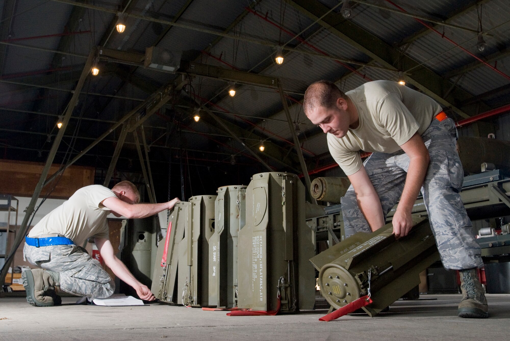 KUNSAN AIR BASE, Republic of Korea -- Senior Airman Michael Burdge and Staff Sgt. Bruce Dooley, 8th Maintenance Squadron, inspects tail assemblies from the MK-82, a 500 pound free fall, general- purpose bomb, Sept. 22. The Airmen are disassembling the MK-82 to preserve service life of the components for future use. (U.S. Air Force photo / Senior Airman Jonathan Steffen)