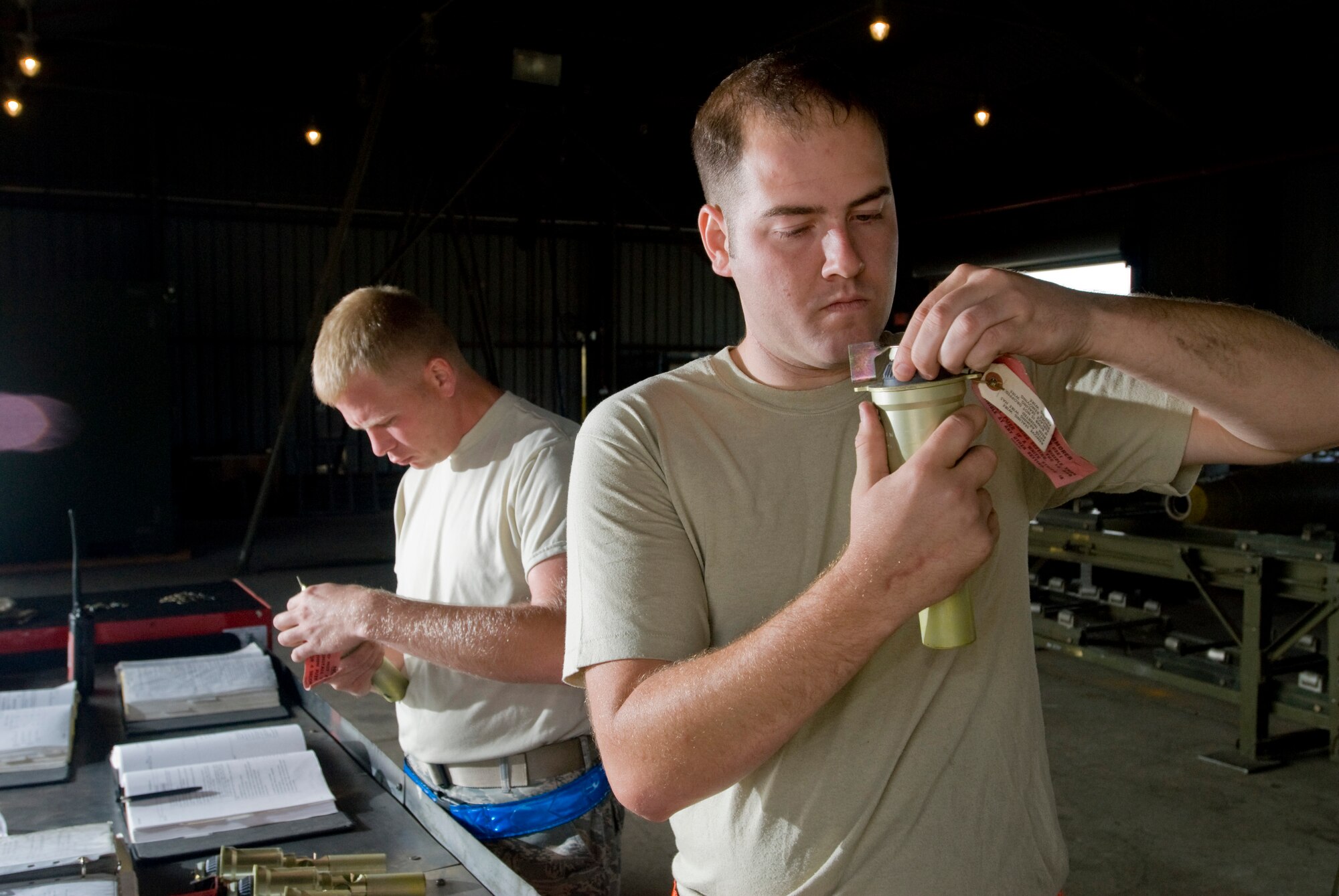 KUNSAN AIR BASE, Republic of Korea -- Staff Sgt. Bruce Dooley and Senior Airman Michael Burdge, 8th Maintenance Squadron, inspects the nose fuse of a MK-82, a 500 pound free fall, general- purpose bomb, Sept. 22. The MK-82 is being disassembled to preserve service life of the components for future use. (U.S. Air Force photo / Senior Airman Jonathan Steffen)