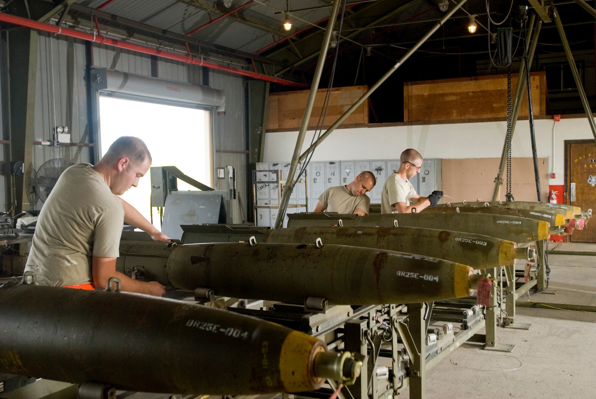KUNSAN AIR BASE, Republic of Korea -- Senior Airman Michael Burdge, Airman 1st Class Robert Locke, and Airman 1st Class Christopher Lewis, 8th Maintenance Squadron, disassembles a MK-82, a 500 pound free fall, general- purpose bomb, Sept. 22. The Airmen are disassembling the MK-82 to preserve service life of the components for future use. (U.S. Air Force photo / Senior Airman Jonathan Steffen)