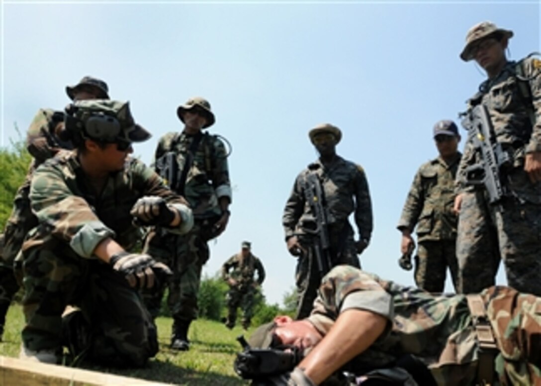 U.S. Navy Petty Officer 2nd Class Susan Hernandezquiles (left) and Petty Officer 1st Class Cliff Gordon, both assigned to the Expeditionary Training Command, demonstrate to members of the Guatemalan navy special forces how to shoot from behind a barricade in San Jose, Guatemala, on Sept. 16, 2009.  The Expeditionary Training Command's five-member Mobile Training Team is deployed to Guatemala to help train elite combat units of the Guatemalan navy.  