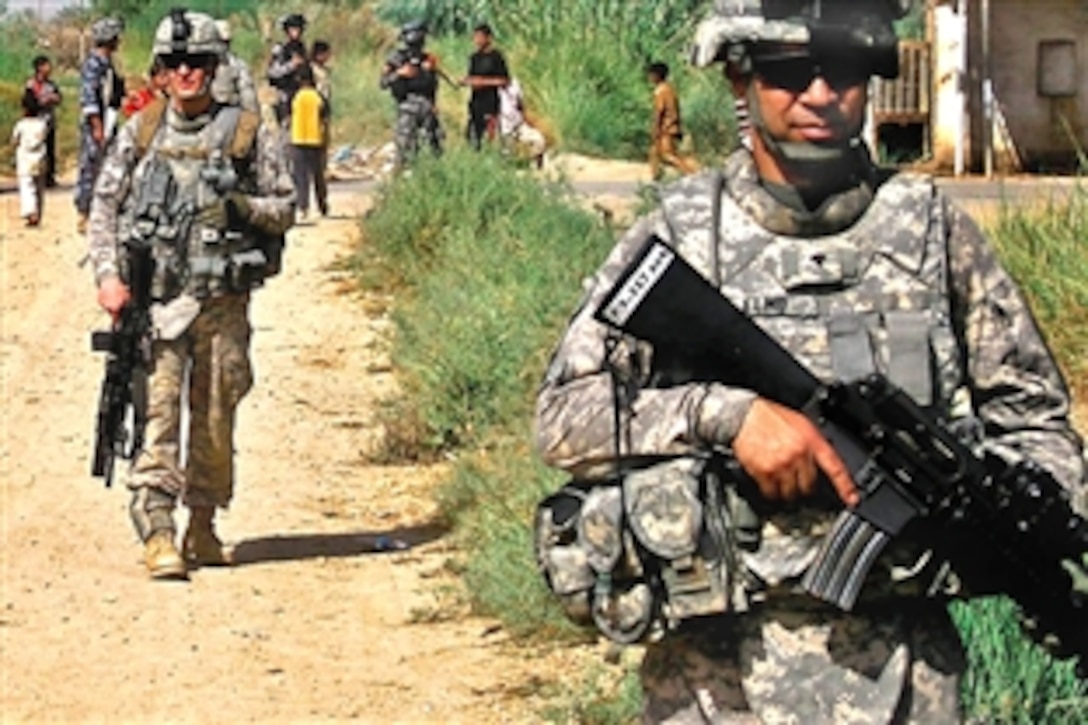 U.S. Army Spc. Elmountassir Mohamed, right, and Spc. Brian Rogers, left, conduct a presence patrol of a small town near Camp Taji, Iraq, Sept. 18, 2009. Mohamed and Rogers are assigned to the 1st Cavalry Division's Company F, 3rd Battalion, 227th Aviation Regiment, 1st Cavalry Brigade.