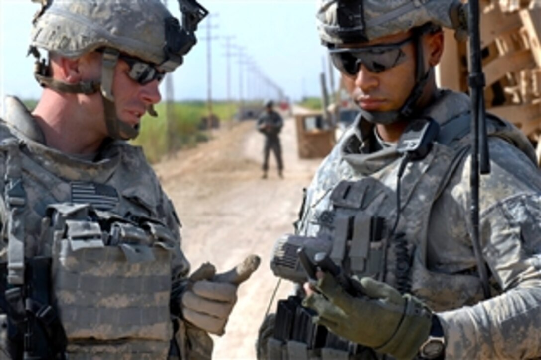 U.S. Army 1st Lt. Will Hargis, right, and Staff Sgt. Daniel Smith, left, check grid coordinates outside of their vehicles before starting to search for a weapons cache in southwestern Baghdad, Sept. 19, 2009. Hargis and Smith are assigned to the 1st Battalion, 150th Armored Reconnaissance Squadron, 30th Heavy Brigade Combat Team.