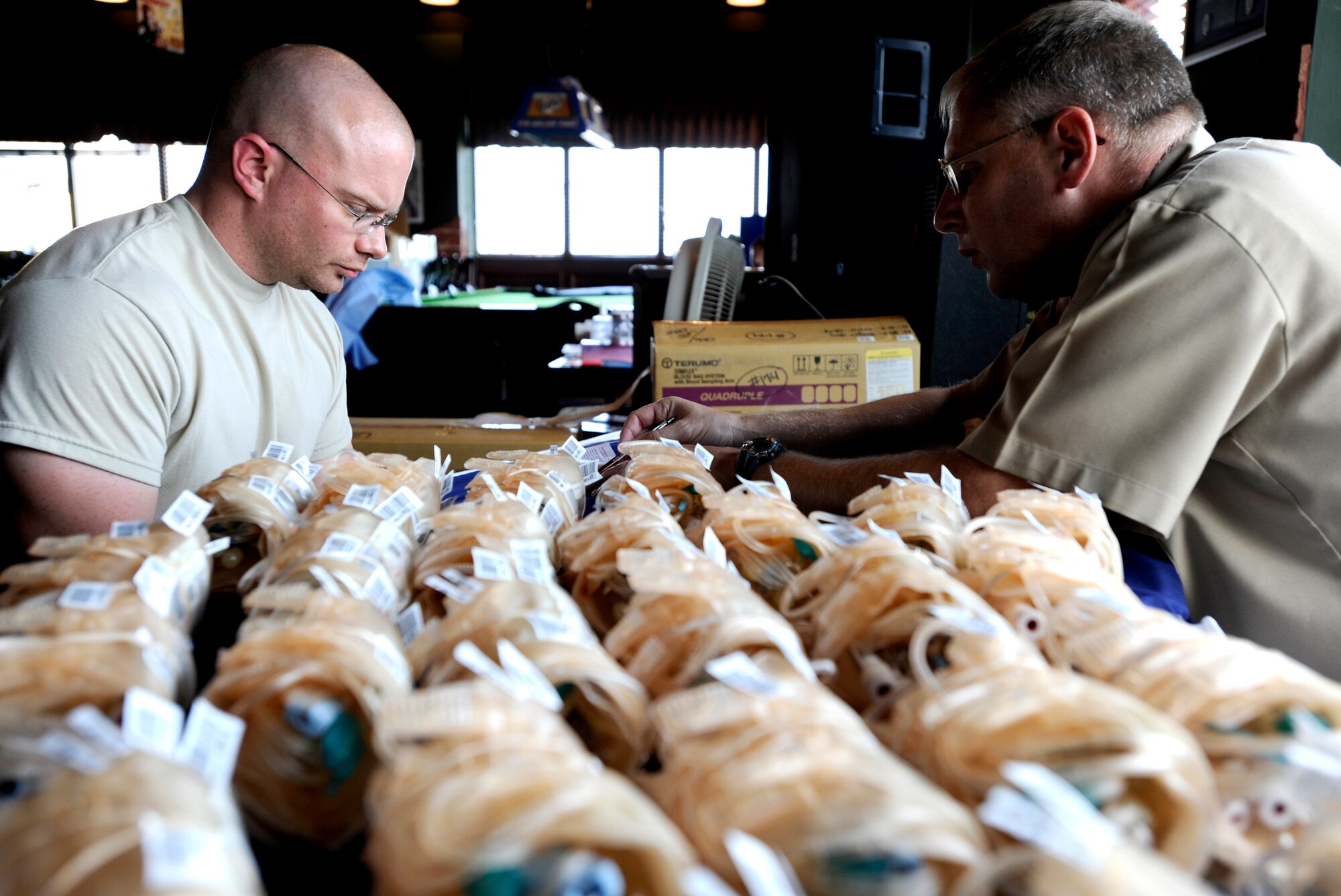 Lt. Commander Michael Roth, left, looks over paperwork before drawing blood during the base-wide blood drive Sept. 23 at Osan Air Base, Republic of Korea. Commander Roth is part of the ten member team from U.S. Pacific Command Armed Services Blood Bank Center in Okinawa, Japan, The PACOM Armed Services Blood Bank distributes blood products to Okinawa, 12 hospitals throughout PACOM, sevices afloat and deployed units of Operations Iraqi and Enduring Freedom.  (U.S. Air Force photo/Senior Airman Stephenie  Wade)