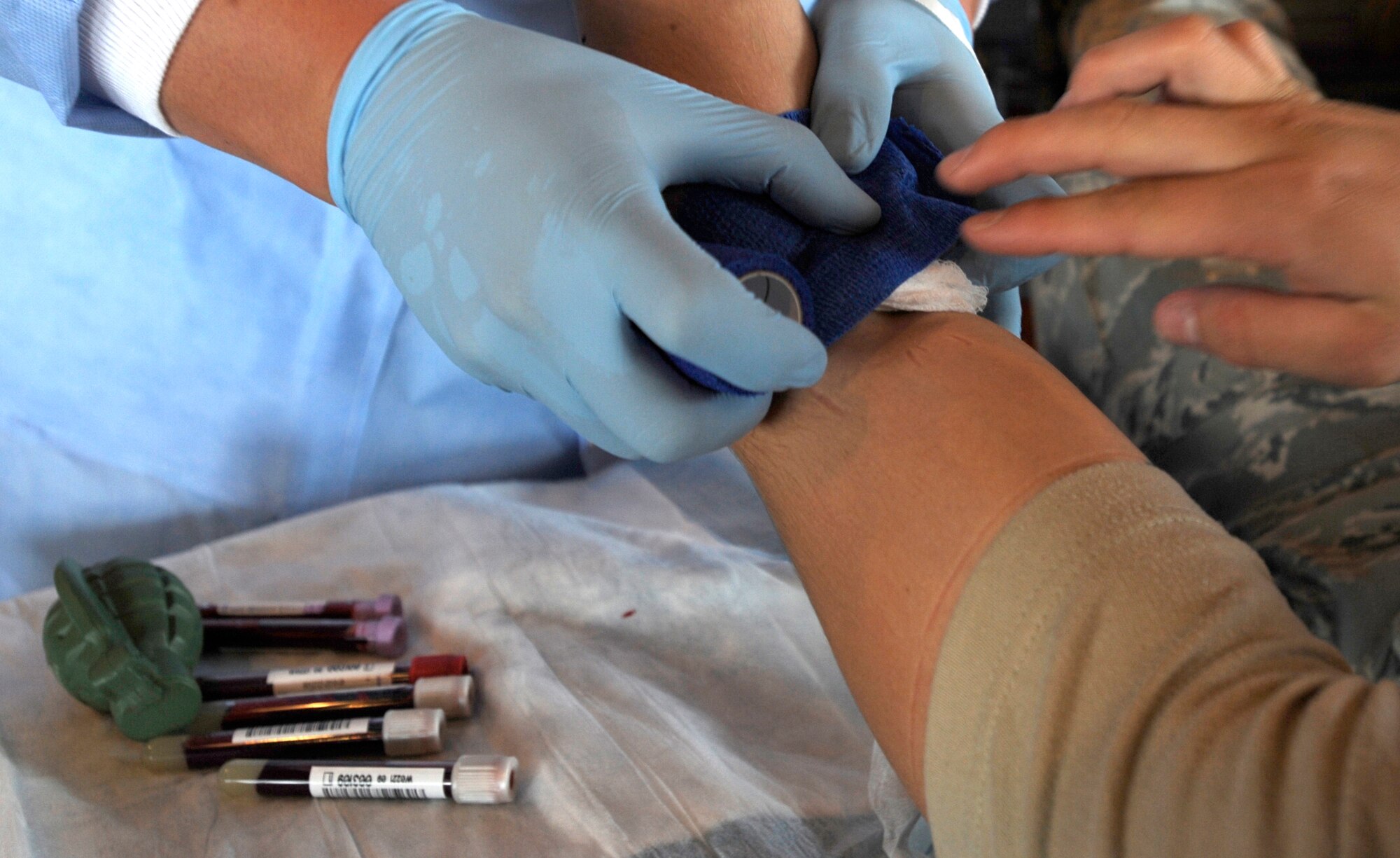Petty Officer Third Class Kris Barber puts a bandage on a donor after drawing blood Sept. 23 at Osan Air Base, Republic of Korea. Petty Officer Barber is part of the ten member team from U.S. Pacific Command Armed Services Blood Bank Center in Okinawa, Japan, The PACOM Armed Services Blood Bank distributes blood products to Okinawa, 12 hospitals throughout PACOM, sevices afloat and deployed units of Operations Iraqi and Enduring Freedom.  (U.S. Air Force photo/Senior Airman Stephenie  Wade)