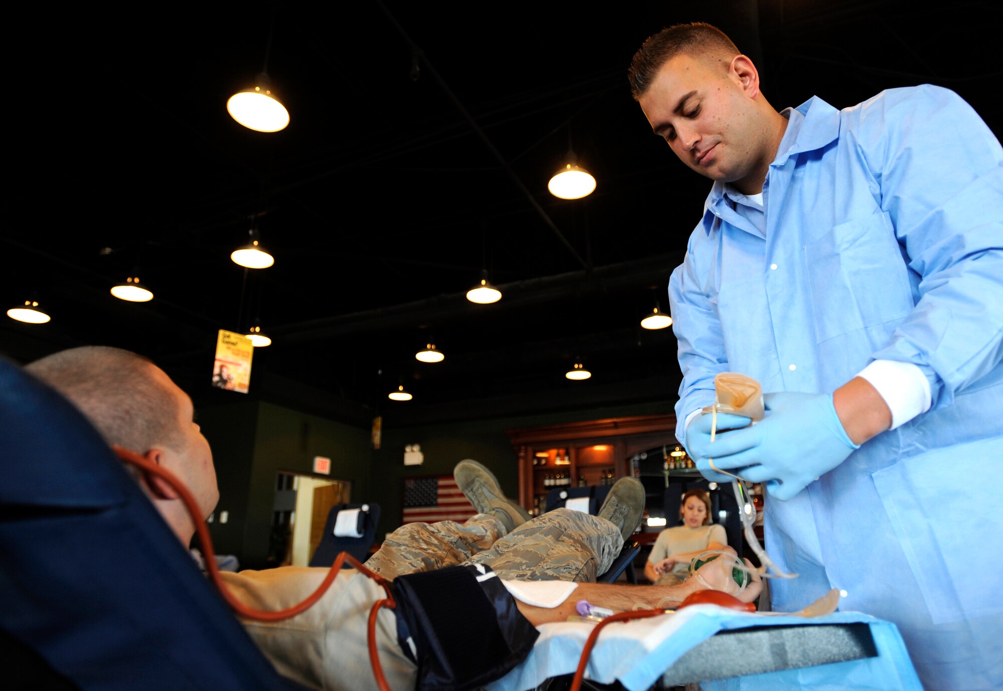 Petty Officer 3rd Class Kris Barber observes as an airman donates blood during the base wide blood drive at Osan Air Base, Republic of Korea, Sept. 23. Petty Officer Barber is one of ten members of the joint team from U.S. Pacific Command Armed Services Blood Bank Center in Okinawa, Japan, TDY to Osan for the drive which was Sept. 22-23. The PACOM Armed Services Blood Bank distributes blood products to Okinawa, 12 hospitals throughout PACOM, sevices afloat and deployed units of Operations Iraqi and Enduring Freedom.  (U.S. Air Force photo/Senior Airman Stephenie  Wade)