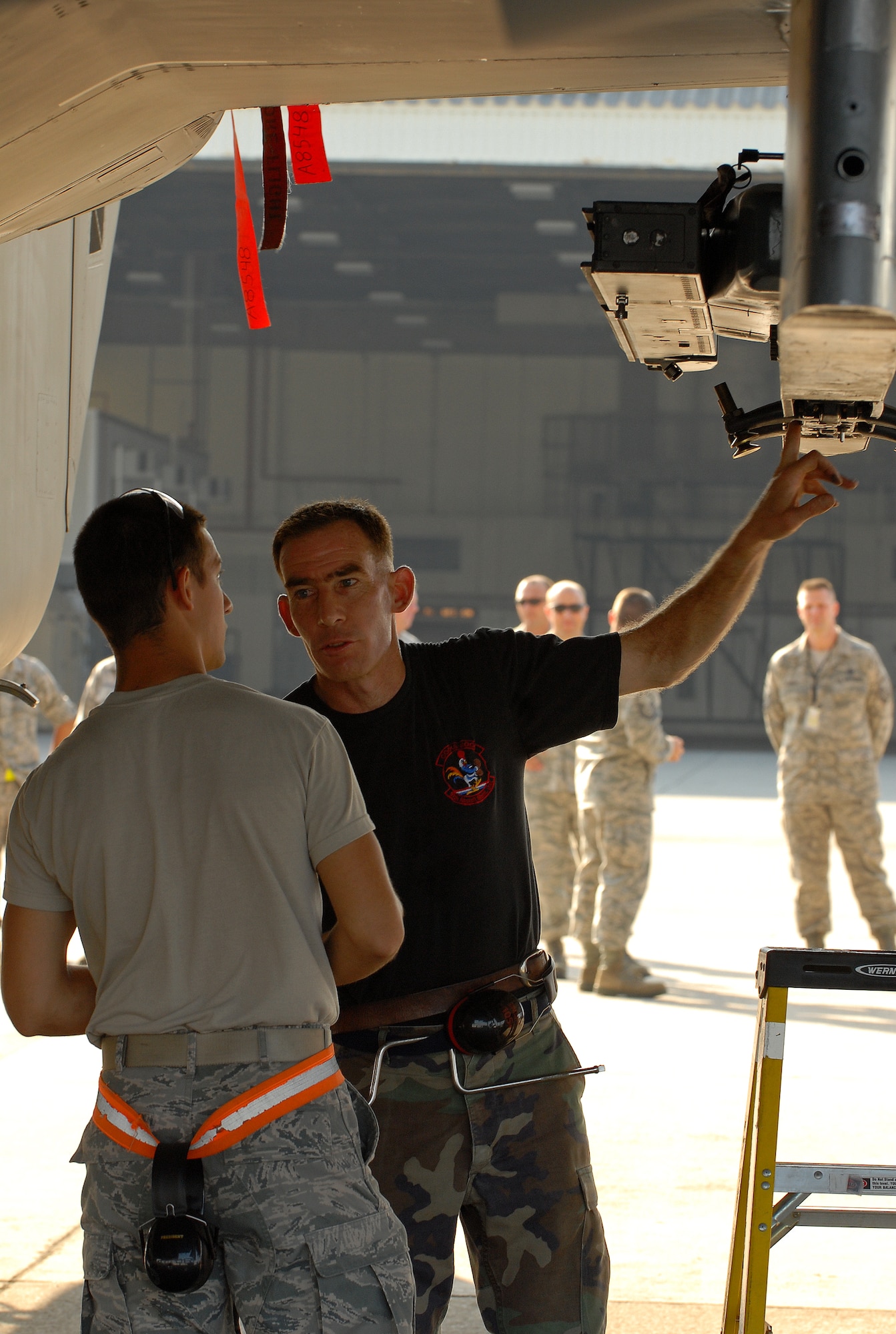 KADENA AIR BASE, Japan -- Senior Master Sgt. Robert Meyer, 67th Aircraft Maintenance Unit's assistant superintendent, took one last opportunity to mentor his unit's newest Airmen like Airman 1st Class Erik Schmidt (left) before retiring Sept. 18. Sergeant Meyer spent more than 17 years of his career at Kadena. "I love the people here and I love the island," he said shortly after completing his final weapons load on an F-15 that was here when he first arrived as an airman basic in 1982. "The local community has always been very welcoming and Kadena is an awesome place to raise kids." (Air Force/Staff Sgt. Jason Lake)