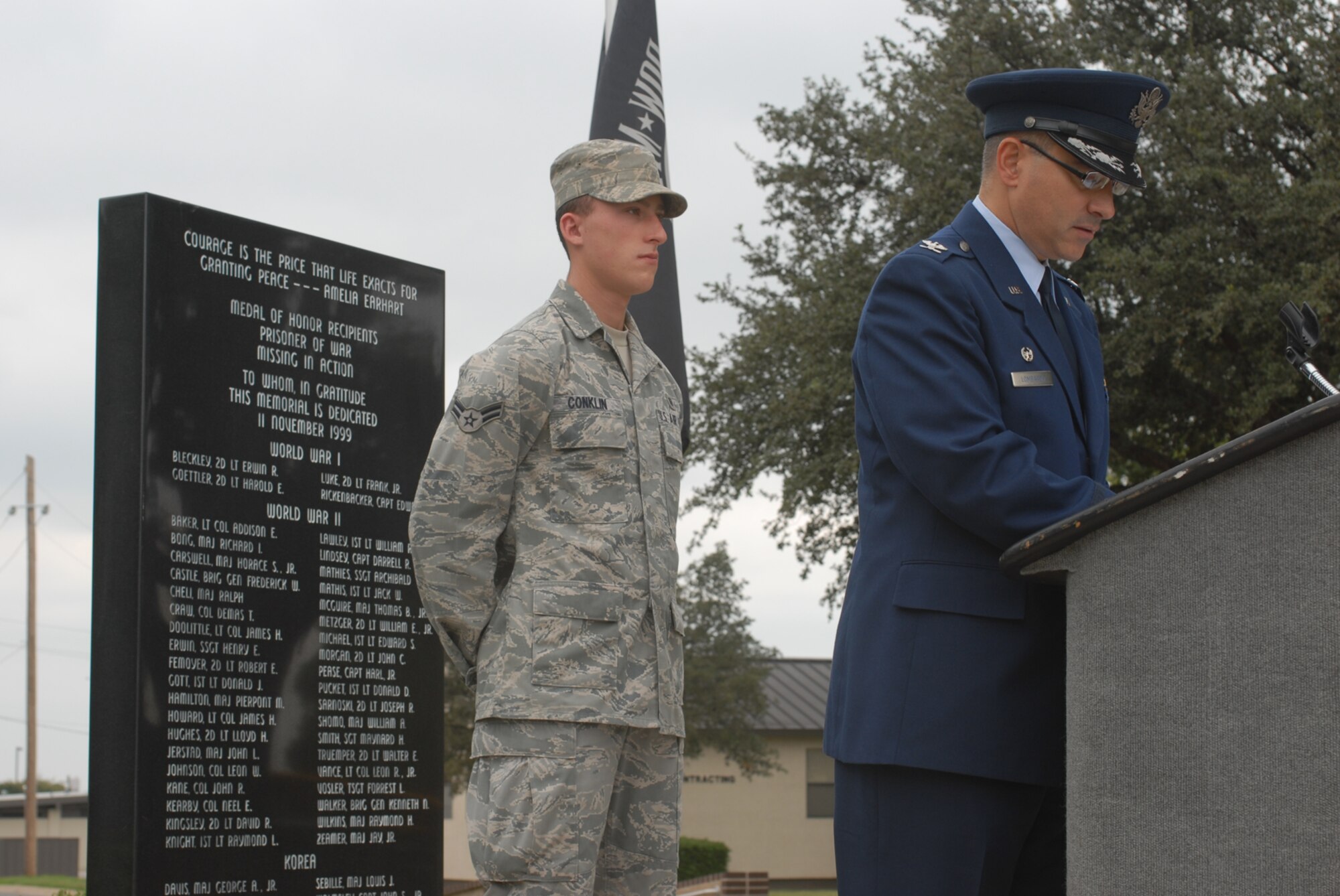 GOODFELLOW AIR FORCE BASE, Texas -- Col. Anthony Lombardo, 17th Training Group commander, reads the names of prisoners of war and servicemembers who are missing in action while Airman 1st Class Timothy Conklin, 17th Medical Operations Squadron, stands vigil at the POW/MIA memorial, Sept. 18, 2009. Base personnel stood a 24-hour vigil honoring POWs and MIAs. (U.S. Air Force photo/Airman Clayton Lenhardt)
