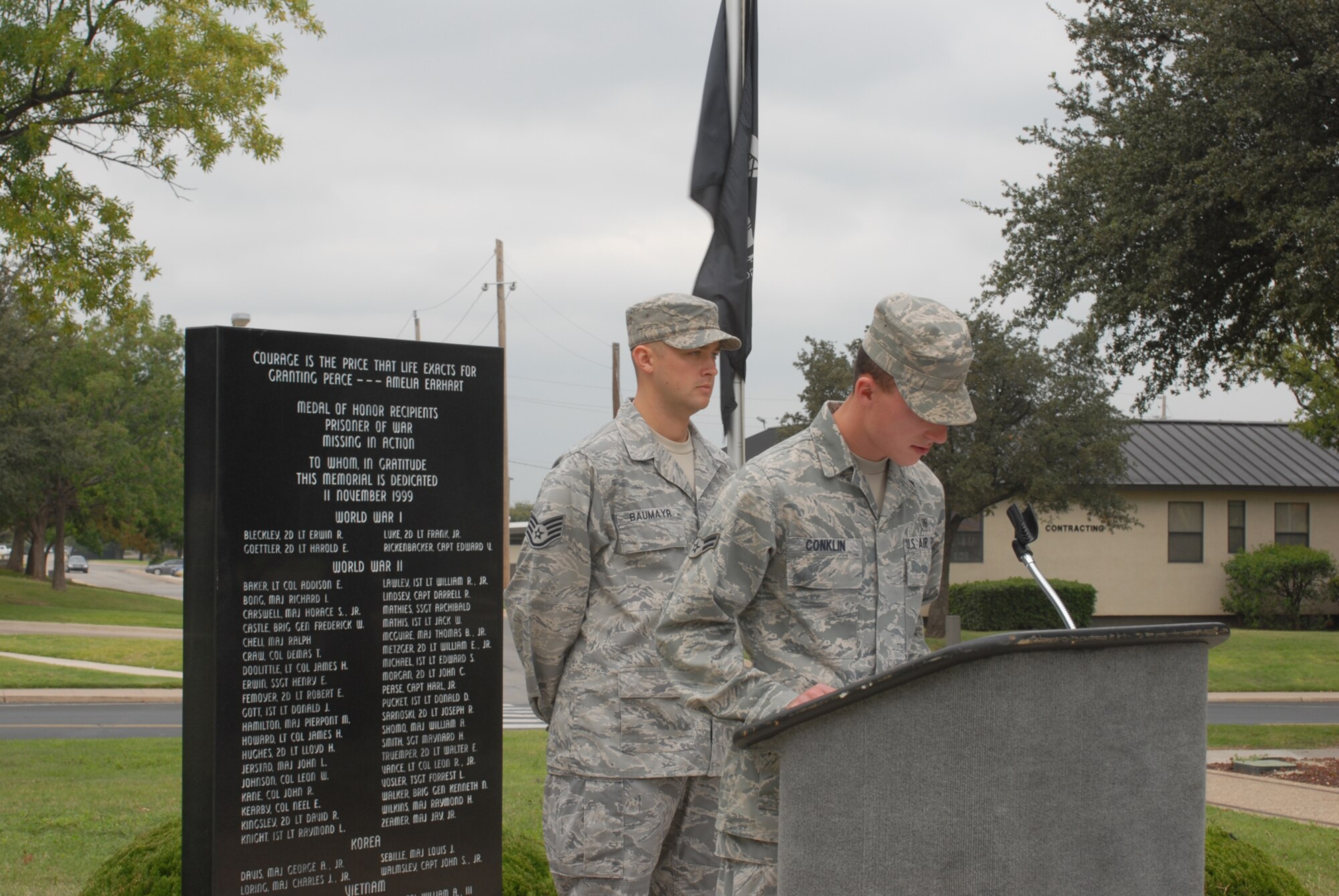 GOODFELLOW AIR FORCE BASE, Texas -- Airman 1st Class Timothy Conklin, 17th Medical Operations Squadron reads the names of prisoners of war and servicemembers who are missing in action while Staff Sgt. Anthony Baumayr, 17th Training Support Squadron, stands vigil at the POW/MIA memorial, Sept. 18, 2009. Base personnel stood a 24-hour vigil honoring POWs and MIAs. (U.S. Air Force photo/Airman Clayton Lenhardt)