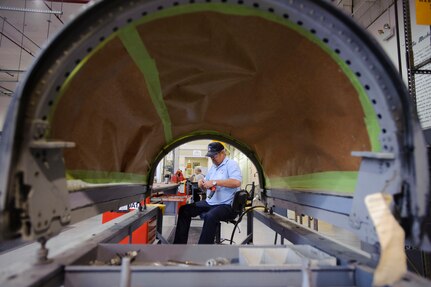 Gary Coats, a structural repair specialist with the 12th Maintenance Directorate, Randolph Air Force Base, Texas, tightens the chuck on his grinder to prep a T-38 canopy for paint after a pressurization seal repair job. (U.S. Air Force photo/Steve Thurow) 