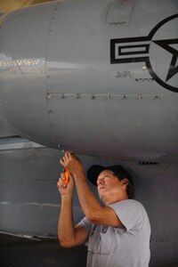 Kirk McBride, a maintenance support unit mechanic with the 12th Maintenance Directorate, Randolph Air Force Base, Texas, tightens the fasteners for an engine cowling covers on a repaired T-1A Jayhawk assigned to the 99th Flying Training Squadron. (U.S. Air Force photo/Steve Thurow)