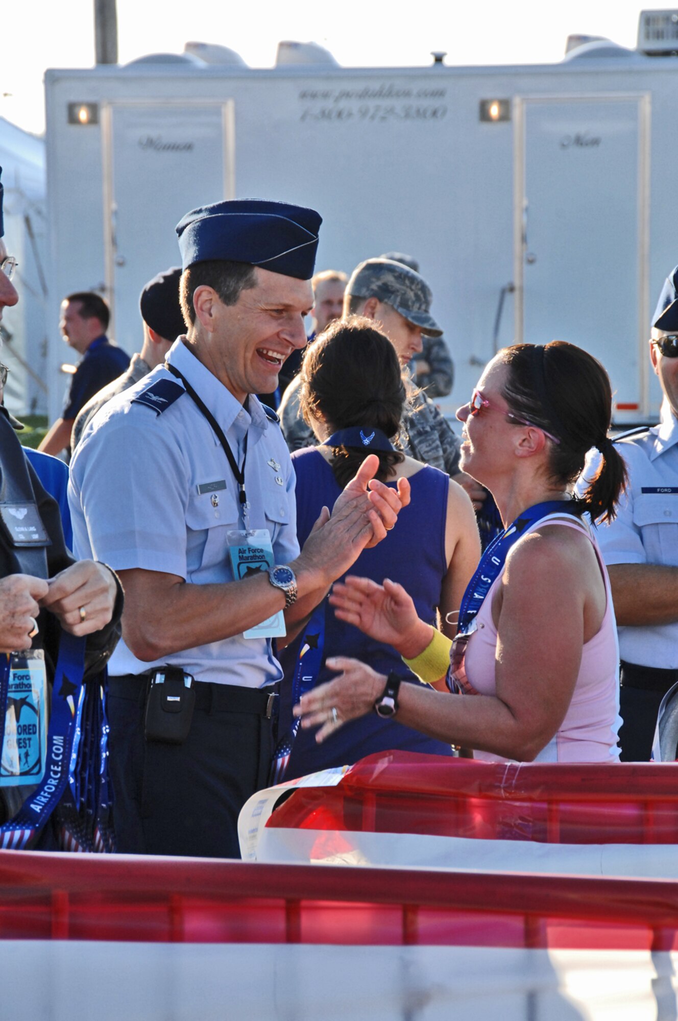 Col. Richard "Duke" Hazdra congratulates a runner at the finish line for the U.S. Air Force Marathon Sept. 19 at Wright-Patterson Air Force Base, Ohio. A record 9,969 runners participated in events which included 5K and 10K races, a half marathon and full marathon. Col. Hazdra is 88th Air Base Wing vice commander.  (Air Force photo/Ben Strasser)