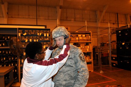 Wadda Harper, Logistics Readiness Division, Checks Master Sgt. John Stuedevant, Headquarters Air Education and Training Command, for proper helmet fit during mobility proccessing.  (U.S. Air Force photo by Rich McFadden)