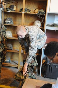 Airman 1st CLass Clinton Patton, 12th Security Forces Squadron, tries on the pants to his protective chemical suit, at the mobility proccessing center. Airman Patton fits himself for proper size, as part of his proccessing and mobility bag set-up. (U.S. Air Force photo by Rich McFadden)