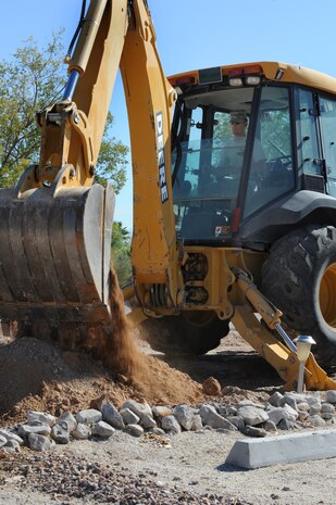 NELLIS AIR FORCE BASE, Nev. -- Tech. Sgt. Martin Spann, a 99th Civil Engineering Squadron pavements and construction operator, uses a backhoe to remove dirt from the surrounding area of a fire hydrant in the Nellis family campground, Sept. 23. The 99th Civil Engineers Squadron and is helping the uilities element replace 12 antiquated fire hydrants throughout the the campground.  (U.S. Air Force photo by Tech Sgt. Michael R. Holzworth)