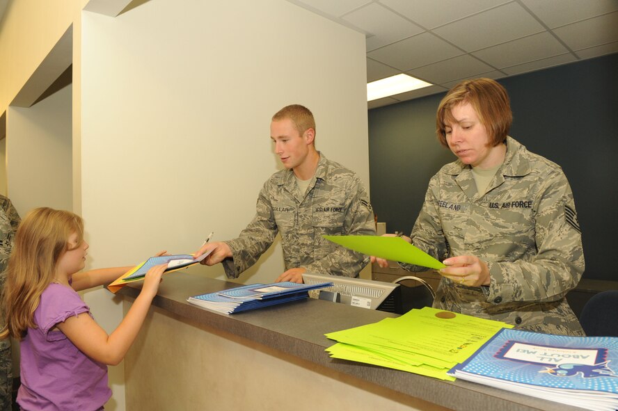 SHAW AIR FORCE BASE, S.C. -- Alexis Bartlett, daughter of Staff Sgt. Jeremiah Bartlett, 20th Medical Support Squadron, receives processing paperwork from Airman 1st Class Phil Collar and Tech. Sgt. Andrea Freeland, 20th Fighter Wing Judge Advocates office, before heading out on a simulated deployment to the fictional country Shawkikistan Sept. 17. Children, ages 4 through 12, got to experience what mom and dad go through when deploying, which gives them a better understanding of the deployment process and helps relieve anxiety. (U.S. Air Force photo/Senior Airman David Minor)