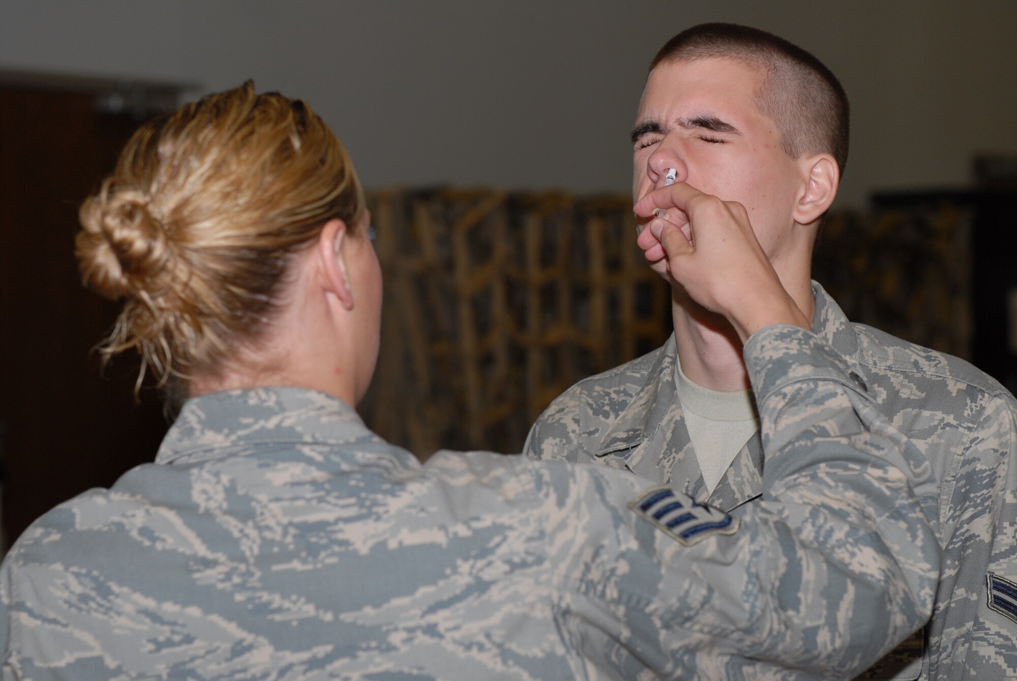 Airman 1st Class Derek Trochman, a 19th Aircraft Maintenance Squadron turbo-prop journeyman, is administered the annual flu mist vaccination by Staff Sgt. Heather Drain, 19th Medical Operations Squadron medical technician, during a disease containment plan exercise held by the 19th Medical Group on base Tuesday and Wednesday. The exercise tested the medical group’s ability to vaccinate a large number of people at once. (U.S. Air Force photo by Senior Airman Nathan Allen)