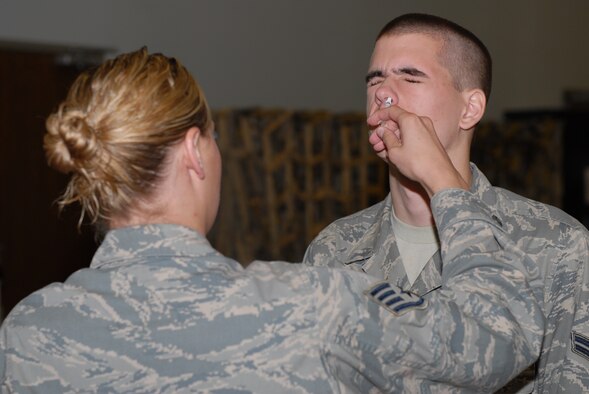 Airman 1st Class Derek Trochman, a 19th Aircraft Maintenance Squadron turbo-prop journeyman, is administered the annual flu mist vaccination by Staff Sgt. Heather Drain, 19th Medical Operations Squadron medical technician, during a disease containment plan exercise held by the 19th Medical Group on base Tuesday and Wednesday. The exercise tested the medical group’s ability to vaccinate a large number of people at once. (U.S. Air Force photo by Senior Airman Nathan Allen)