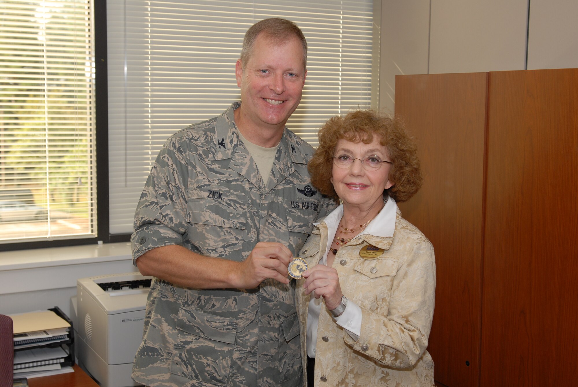 Col. Mike Zick, 19th Airlift Wing vice commander, presents a commander's coin to Terry Shaw, 19th Force Support Squadron school liaison officer, for her selection as the Combat Airlifter of the Week. Ms. Shaw’s accomplishments include working with the Pulaski County Special School District and the Arkansas Department of Education to review and successfully realign the requirement of taking an Arkansas History course for 9th grade and above students transferring into the state. She also assists families moving to the area with school selection based on their student's extracurricular aptitudes.