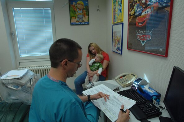 United States Air Force Maj. (Dr.) Jonathan Evan, 86th Medical Group general dentist, examines Hayden Voss during his first trip to the dentist. Dentists at the 86th Dental Squadron see hundreds of children each year from the Kaiserslautern Military Community. For the initial visit, Doctor Evans emphasizes the importance of parentally involvement and the child's overall dental well-being. (U.S. Air Force photo by Tech. Sgt. Michael Voss) 
