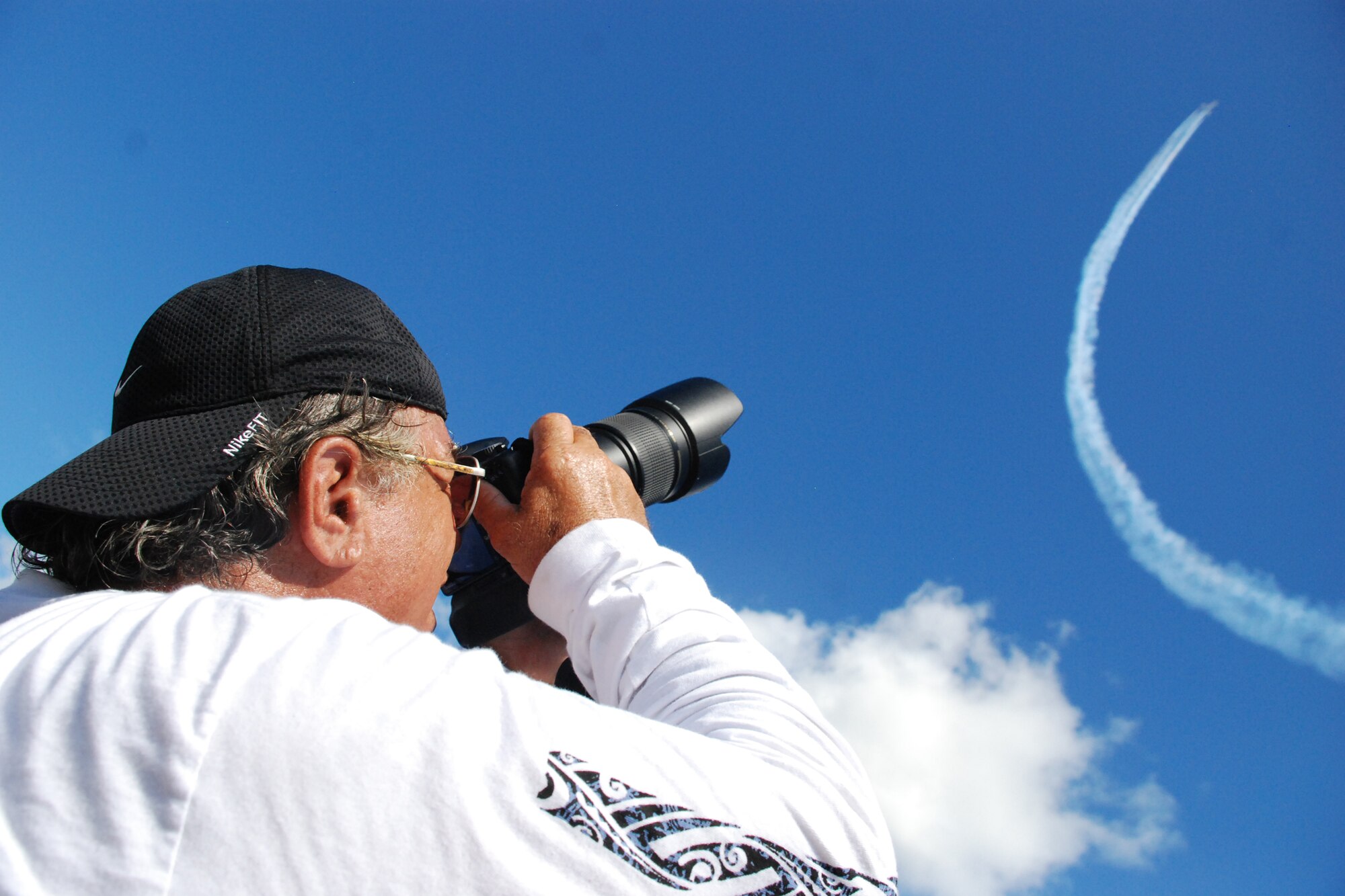 HICKAM AIR FORCE BASE, Hawaii -- Al Cofran, of Kailua, Hawaii, photograph the Thunderbirds during the during the "Wings Over the Pacific," Open House Sept. 20. Shutter bugs from around the world came to Hickam to watch the Thunderbirds take to the air and capture their best imagery. The Thunderbirds demonstrate the capabilities the F-16 Fighting Falcon by performing combat maneuvers during their aerial demonstration. This is Hickam's first open house since 2003, and a crowd of nearly 100,000 paid a visit during the weekend. (U.S. Air Force photo/Staff Sgt. Mike Meares)