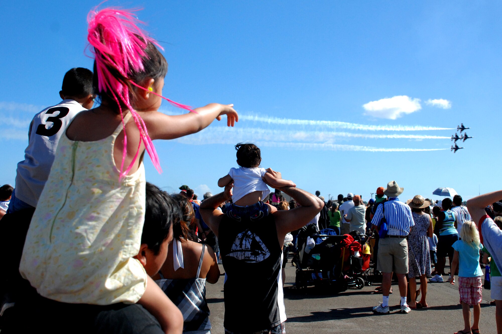 HICKAM AIR FORCE BASE, Hawaii -- Ashley Kodama, 4-years-old, is drowned out as she tries to tell her dad, Kyle Kodama, to look at the U.S. Air Force Thunderbirds in diamond formation passing in front of a crowd of more than 57,000 people. The Thunderbirds demonstrate the capabilities the F-16 Fighting Falcon by performing combat maneuvers during their aerial demonstration. This is Hickam's first open house since 2003, and a crowd of nearly 100,000 paid a visit during the weekend. The Kodama's are from Waimanalo, Hawaii. (U.S. Air Force photo/Staff Sgt. Mike Meares)