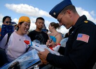 HICKAM AIR FORCE BASE, Hawaii -- Maj. Sean Gustafson, Thunderbird #4 slot pilot, signs autographs for fans after their final performance Sept. 20 at Hickam's 2009 "Wings Over the Pacific" Open House. The Thunderbirds demonstrate the capabilities the F-16 Fighting Falcon by performing combat maneuvers during their aerial demonstration. This is Hickam's first open house since 2003, and a crowd of nearly 100,000 paid a visit during the weekend. (U.S. Air Force photo/Staff Sgt. Mike Meares)