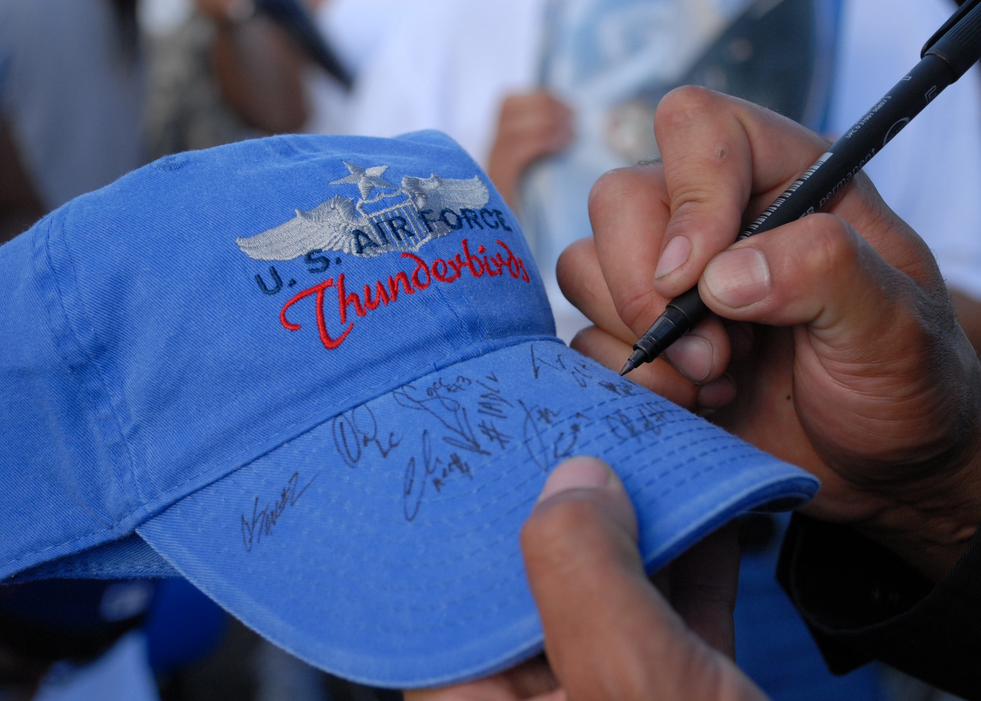 HICKAM AIR FORCE BASE, Hawaii -- Fans clamored for position against a fence seeking autographs from The Thunderbirds after their final performance Sept. 20 at Hickam's 2009 "Wings Over the Pacific" Open House. The Thunderbirds demonstrate the capabilities the F-16 Fighting Falcon by performing combat maneuvers during their aerial demonstration. This is Hickam's first open house since 2003, and a crowd of nearly 100,000 paid a visit during the weekend. (U.S. Air Force photo/Staff Sgt. Mike Meares)
