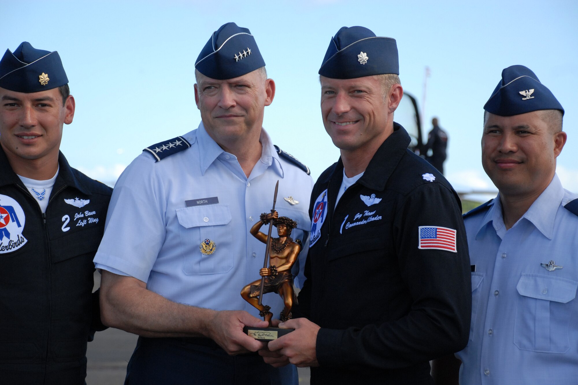 HICKAM AIR FORCE BASE, Hawaii -- Gen. Gary North, Commander, Pacific Air Forces, presents a Kekoa statue as a token of thanks for their support to Hickam?s 2009 ?Wings Over the Pacific? Open House. The Thunderbirds demonstrate the capabilities the F-16 Fighting Falcon by performing combat maneuvers during their aerial demonstration. This is Hickam's first open house since 2003, and a crowd of nearly 100,000 paid a visit during the weekend. (U.S. Air Force photo/Staff Sgt. Mike Meares)