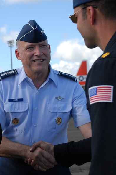 HICKAM AIR FORCE BASE, Hawaii -- Gen. Gary North, Commander, Pacific Air Forces, presents a Kekoa statue as a token of thanks for their support to Hickam?s 2009 ?Wings Over the Pacific? Open House. The Thunderbirds demonstrate the capabilities the F-16 Fighting Falcon by performing combat maneuvers during their aerial demonstration. This is Hickam's first open house since 2003, and a crowd of nearly 100,000 paid a visit during the weekend. (U.S. Air Force photo/Staff Sgt. Mike Meares) 