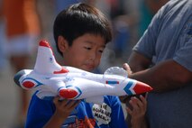 HICKAM AIR FORCE BASE, Hawaii -- Gavin Onizuka, 9, plays with an inflatable Thunderbird toy during the Sept. 20 performance of the U.S. Air Force Thunderbirds at Hickam?s 2009 ?Wings Over the Pacific? Open House before a crowd of more than 57,000. The Thunderbirds demonstrate the capabilities the F-16 Fighting Falcon by performing combat maneuvers during their aerial demonstration. This is Hickam's first open house since 2003, and a crowd of nearly 100,000 paid a visit during the weekend. (U.S. Air Force photo/Staff Sgt. Mike Meares)