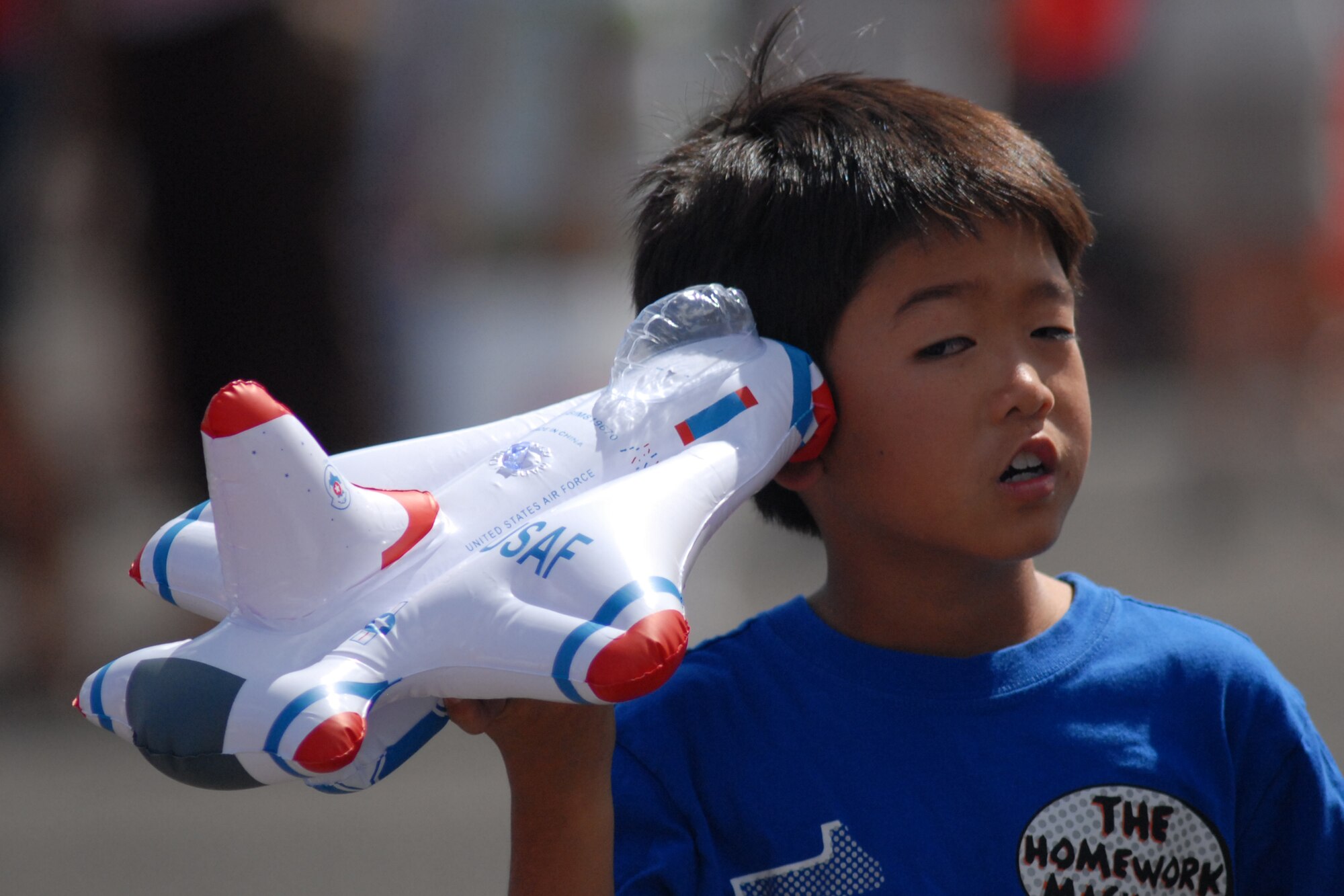 HICKAM AIR FORCE BASE, Hawaii -- Gavin Onizuka, 9, plays with an inflatable Thunderbird toy during the Sept. 20 performance of the U.S. Air Force Thunderbirds at Hickam?s 2009 ?Wings Over the Pacific? Open House before a crowd of more than 57,000. The Thunderbirds demonstrate the capabilities the F-16 Fighting Falcon by performing combat maneuvers during their aerial demonstration. This is Hickam's first open house since 2003, and a crowd of nearly 100,000 paid a visit during the weekend. (U.S. Air Force photo/Staff Sgt. Mike Meares)