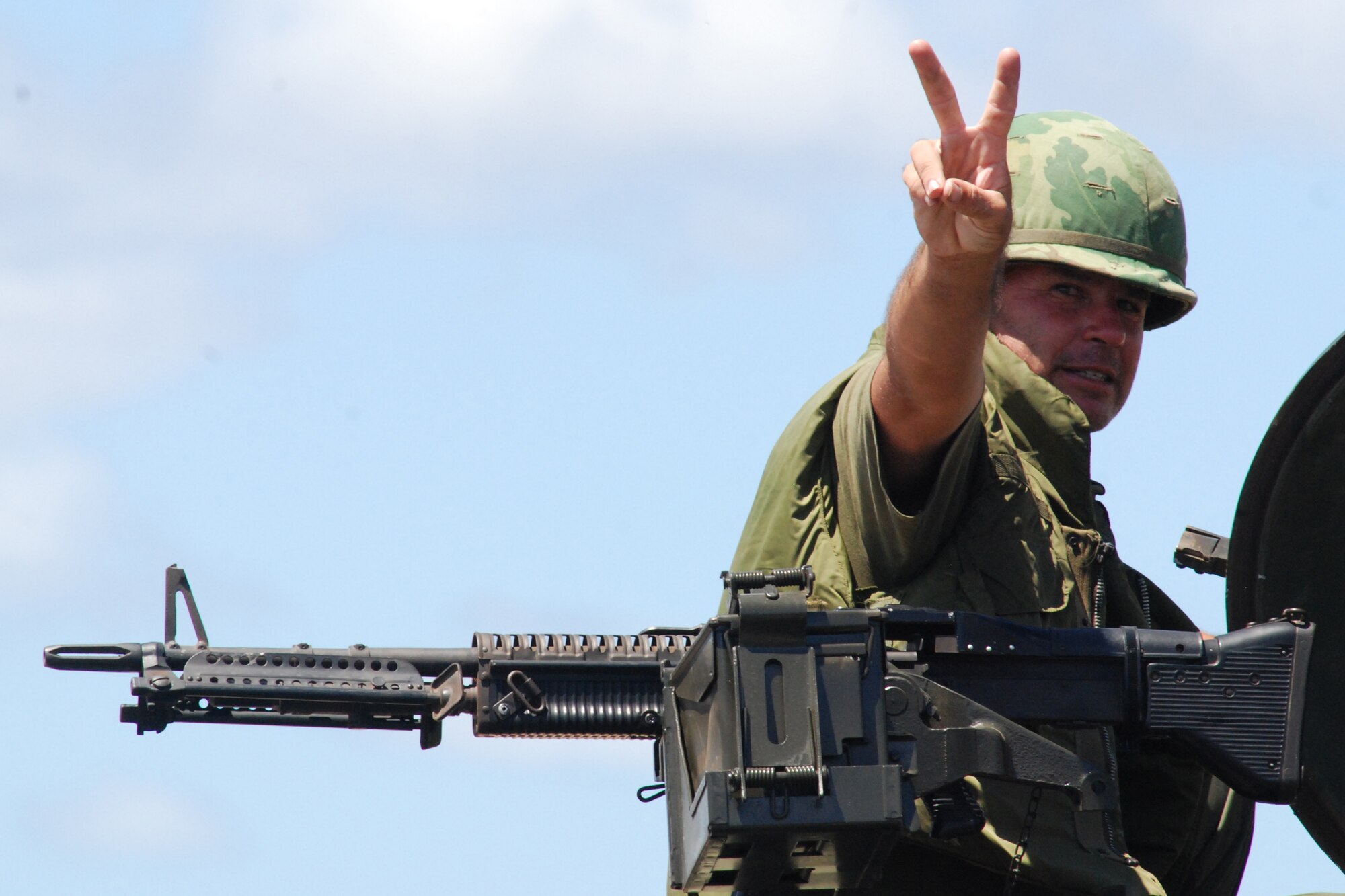 HICKAM AIR FORCE BASE, Hawaii -- Brad Hayes, a volunteer with the Hawaii Museum of Military Vehicles, displays a popular symbol from the Vietnam era while sitting on top of an armored personnel carrier restored from the Vietnam era at the "Wings over the Pacific" Open House Sept. 19. Mr. Hayes is a former Marine Corps corporal and volunteers for the HMMV. The Thunderbirds, U.S. Air Force Demonstration Squadron, were the headliners during the open house. They demonstrate the capabilities the F-16 Fighting Falcon by performing combat maneuvers during their aerial demonstration. This is Hickam's first open house since 2003, and a crowd of nearly 100,000 paid a visit during the weekend. (U.S. Air Force photo/Staff Sgt. Mike Meares)
