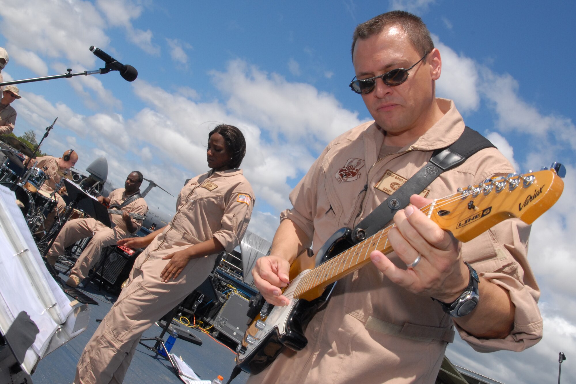 HICKAM AIR FORCE BASE, Hawaii -- Staff Sgt. Greg Lacy, Pacific Air Force Band guitar player, jams to Sweet Home Alabama, during a performance at the Open House ?Wings Over the Pacific? Sept. 19. The Thunderbirds, U.S. Air Force Demonstration Squadron, were the headliners during the open house. They demonstrate the capabilities the F-16 Fighting Falcon by performing combat maneuvers during their aerial demonstration. This is Hickam's first open house since 2003, and a crowd of nearly 100,000 paid a visit during the weekend. (U.S. Air Force photo/Staff Sgt. Mike Meares)