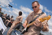 HICKAM AIR FORCE BASE, Hawaii -- Staff Sgt. Greg Lacy, Pacific Air Force Band guitar player, jams to Sweet Home Alabama, during a performance at the Open House ?Wings Over the Pacific? Sept. 19. The Thunderbirds, U.S. Air Force Demonstration Squadron, were the headliners during the open house. They demonstrate the capabilities the F-16 Fighting Falcon by performing combat maneuvers during their aerial demonstration. This is Hickam's first open house since 2003, and a crowd of nearly 100,000 paid a visit during the weekend. (U.S. Air Force photo/Staff Sgt. Mike Meares)