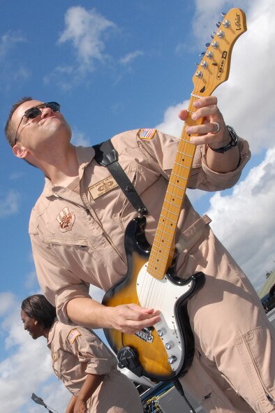 HICKAM AIR FORCE BASE, Hawaii -- Staff Sgt. Greg Lacy, Pacific Air Force Band guitar player, jams to Sweet Home Alabama, during a performance at the Open House ?Wings Over the Pacific? Sept. 19. The Thunderbirds, U.S. Air Force Demonstration Squadron, were the headliners during the open house. They demonstrate the capabilities the F-16 Fighting Falcon by performing combat maneuvers during their aerial demonstration. This is Hickam's first open house since 2003, and a crowd of nearly 100,000 paid a visit during the weekend. (U.S. Air Force photo/Staff Sgt. Mike Meares)