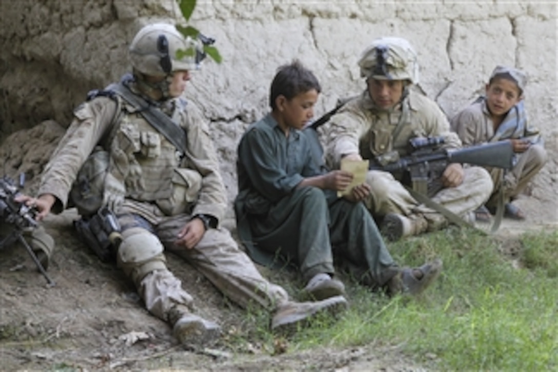 U.S. Marine Corps Lance Cpl. Kristopher Marku and Lance Cpl. Andres Luna, both with Bravo Company, 1st Battalion, 5th Marine Regiment, teach English words to an Afghan boy during a security patrol in the Nawa district of the Helmand province of Afghanistan on Sept. 3, 2009.  Marines conduct security patrols to decrease insurgent activity and gain the trust of the Afghan people.  The 1st Battalion, 5th Marine Regiment is deployed with Regimental Combat Team 3 to conduct counterinsurgency operations in partnership with Afghan National Security Forces in southern Afghanistan.  