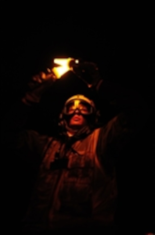 U.S. Navy Petty Officer 3rd Class Cory Stallings uses yellow flashlights to signal aircraft on the flight deck of the aircraft carrier USS John C. Stennis (CVN 74) in the Pacific Ocean on Sept. 19, 2009.  The Stennis is underway conducting fleet replacement squadron carrier qualifications off the coast of southern California.  