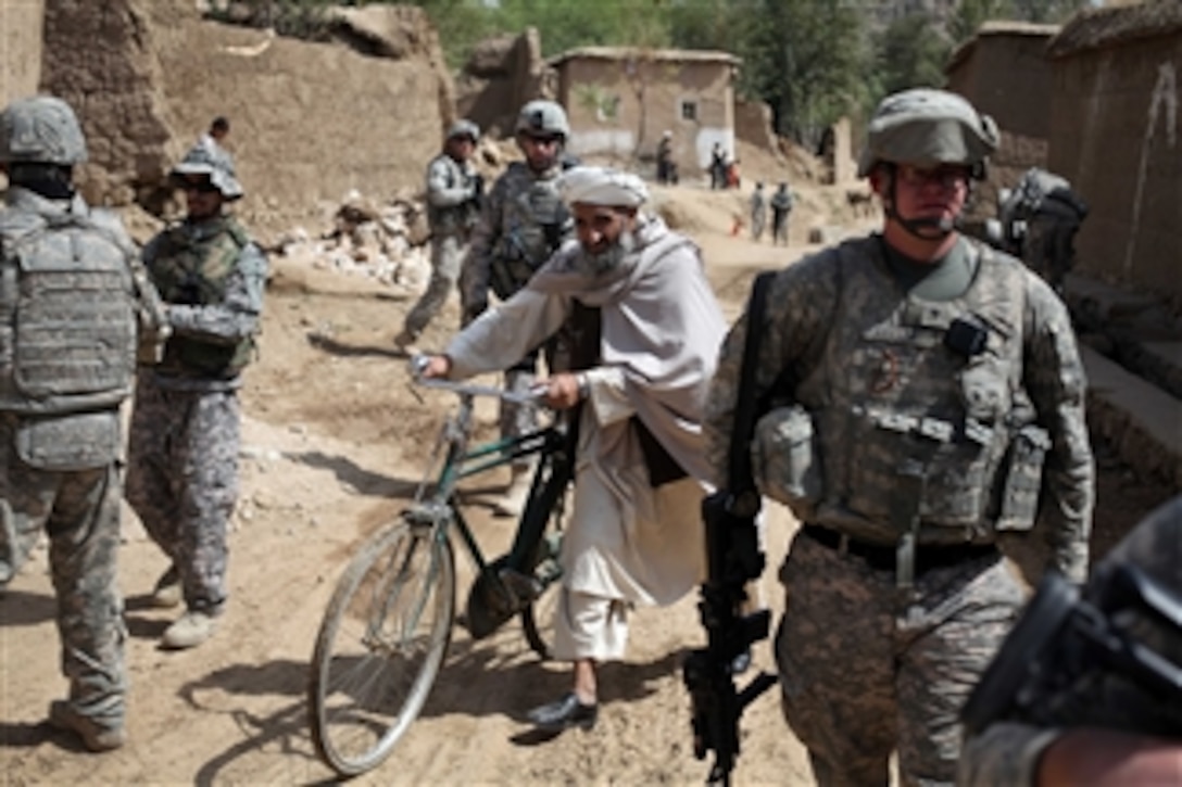 An Afghan man walks between groups of U.S. Army soldiers assigned to the Kapisa-Parwan Provincial Reconstruction Team during a visit to assess the progress of a road construction project in the Kohistan District, Afghanistan, on Sept. 16, 2009.  