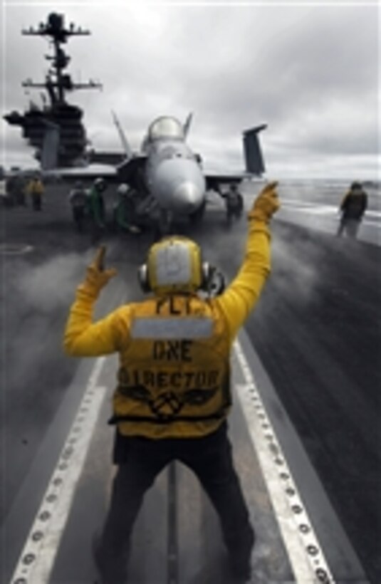 U.S. Navy Petty Officer 2nd Class Raul Barrios guides an F/A-18C Hornet aircraft from Strike Fighter Squadron 125 onto catapult one aboard the aircraft carrier USS John C. Stennis (CVN 74) in the Pacific Ocean on Sept. 19, 2009.  The Stennis is underway conducting fleet replacement squadron carrier qualifications off the coast of southern California.  