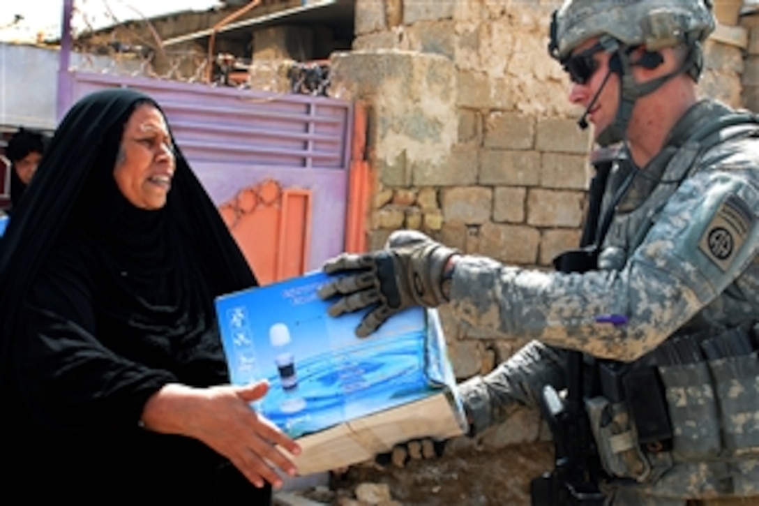U.S. Army 1st Lt. James Teeter gives a water filter to an Iraqi woman in the village of al-Tameem, Iraq, Sept. 21, 2009. Teeter is assigned to the 82nd Airborne Division's 5th Squadron, 73rd Airborne Reconnaissance Cavalry Regiment, 3rd Brigade Combat Team.