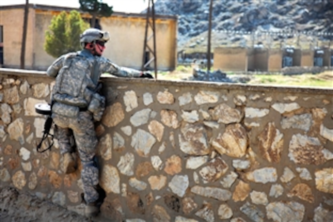 U.S. Army Sgt. Chris Miller jumps onto a stone wall to get a better view for any suspicious activity while providing security at the Kohistan district, Afghanistan, Sept. 16, 2009.  Miller is assigned to the Kapisa-Parwan Provincial Reconstruction Team.
