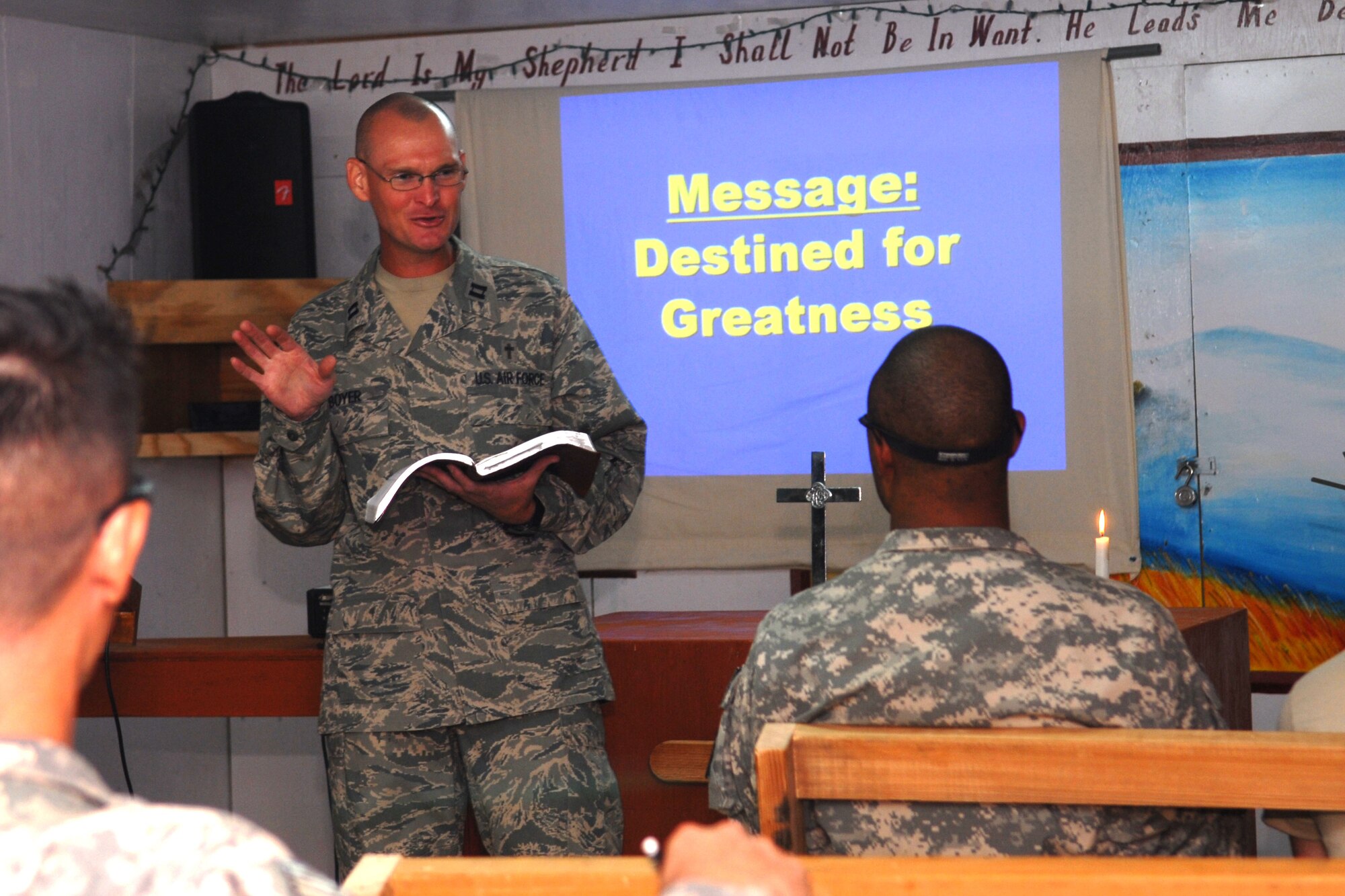 FORWARD OPERATING BASE WRIGHT, Afghanistan -- U.S. Air Force Chaplain (Capt.) Eric Boyer (standing) leads a service for deployed members at Foward Operating Base Wright, Afghanistan, Sept. 21, 2009.  This service is one of several ministry opportunities that Chaplain Boyer participates in and offers to all military members who are stationed at or pass through the forward operating base.  The chaplain is deployed from the 12th Flying Training Wing at Randolph Air Force Base, Texas, and a native of Knoxville, Tenn. He is assigned to the Combined Joint Task Force-82 chaplain corps and was sent forward to FOB Wright.  (U.S. Air Force photo/Tech. Sgt. Brian Boisvert)