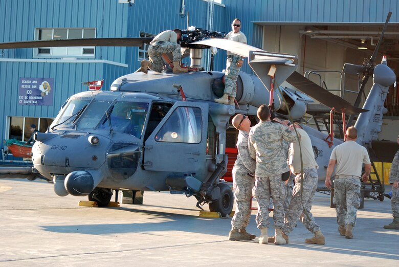 GANDER, Newfoundland - Air Force Reserve combat rescue crew chiefs break out their wrenches and special tools to unfold and prepare this HH-60G Pave Hawk helicopter for a week of competition exercises here with the Canadian rescue forces Sept. 21. (U.S. Air Force Photo/Capt. Cathleen Snow)